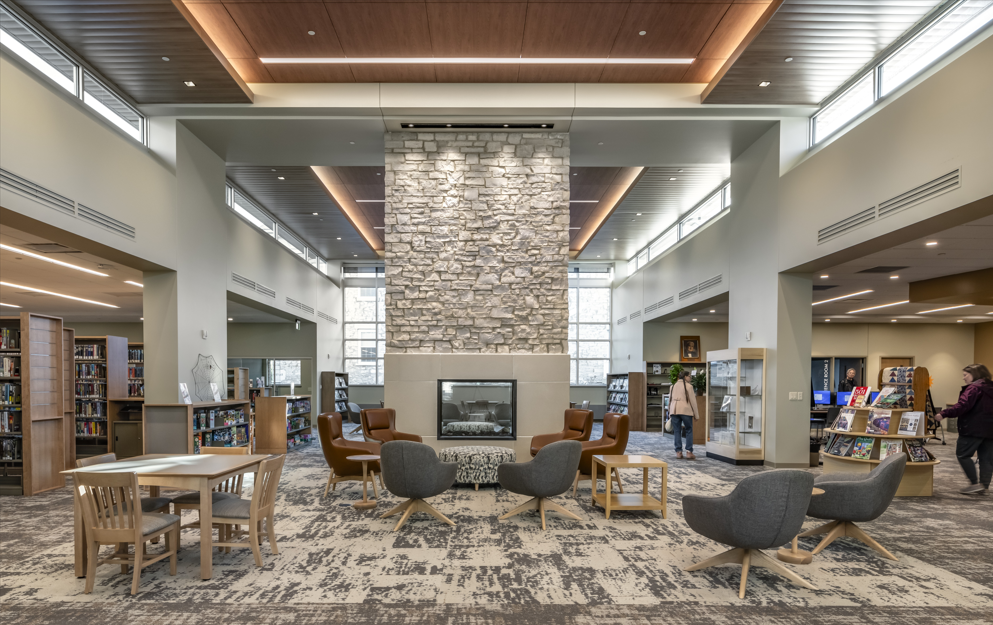 A photo of a large open seating area with fireplace in the middle